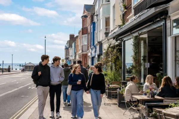 Students walking through Southsea near cafes, local shops, and the seafront, showing relaxed coastal student living in Portsmouth.